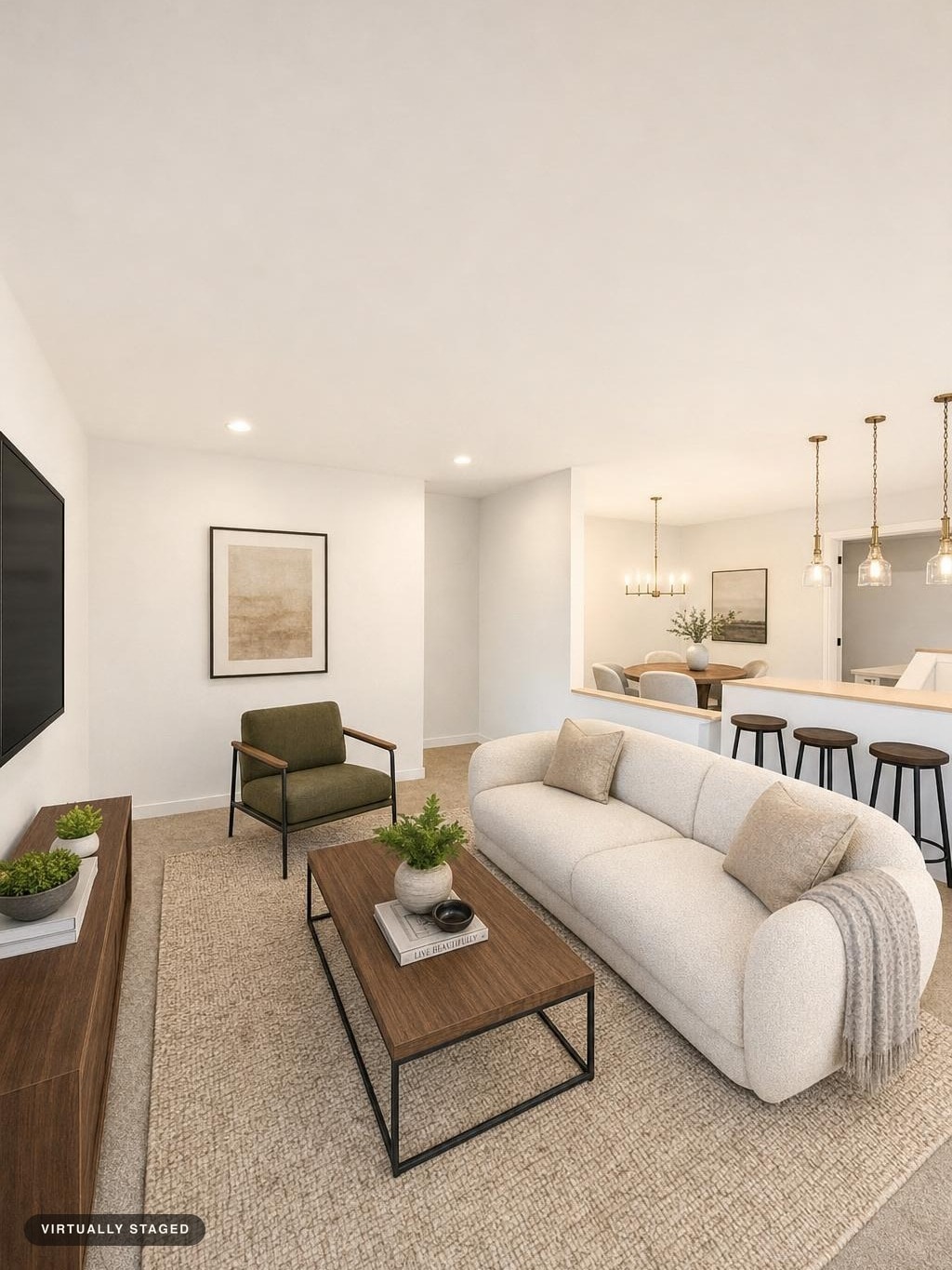Modern living room with rounded beige sofa, olive armchair, wooden coffee table, TV stand, and bar stools in an open plan space.