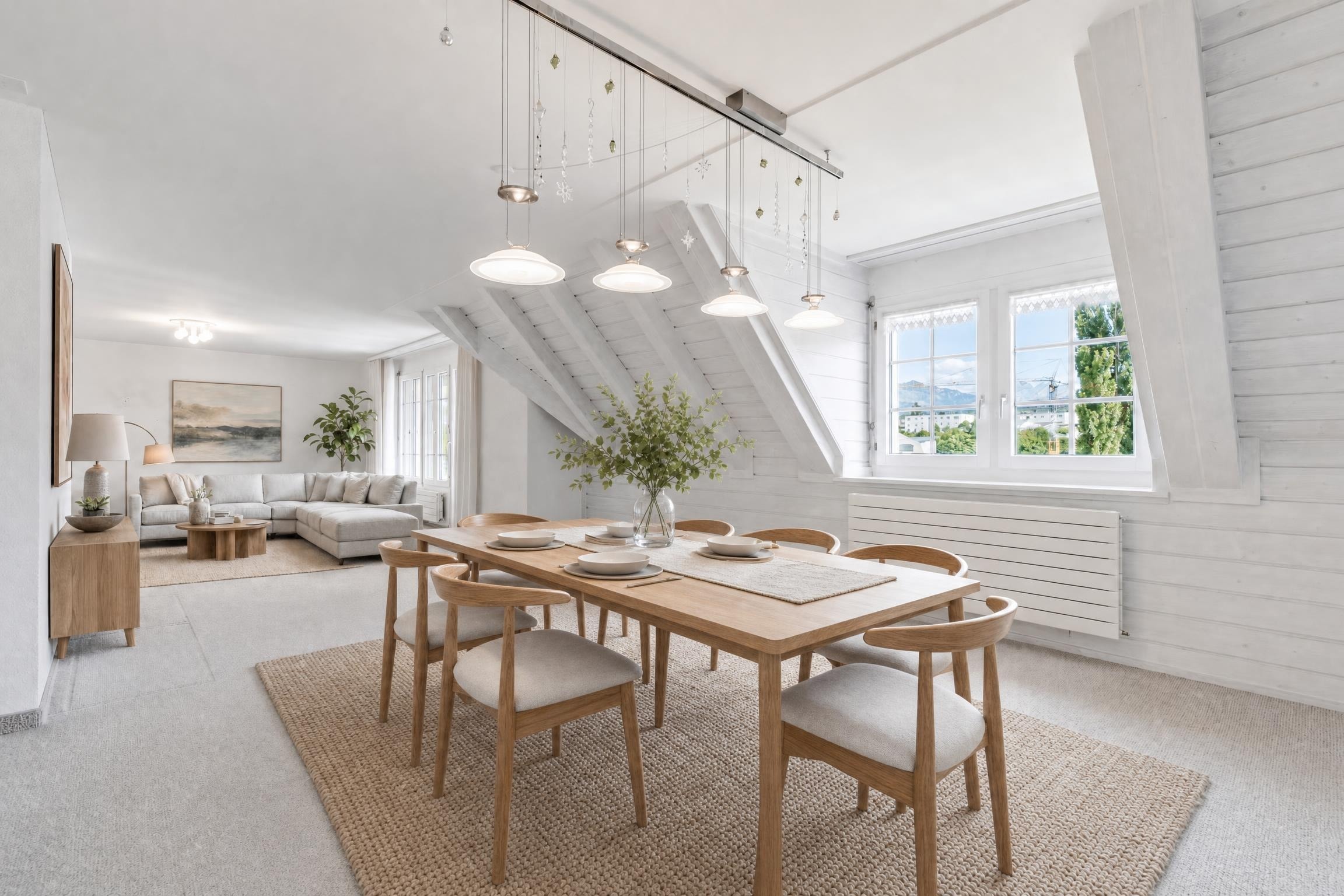 Scandinavian dining room with wooden table and chairs, pendant lights, and a large woven rug under the table.