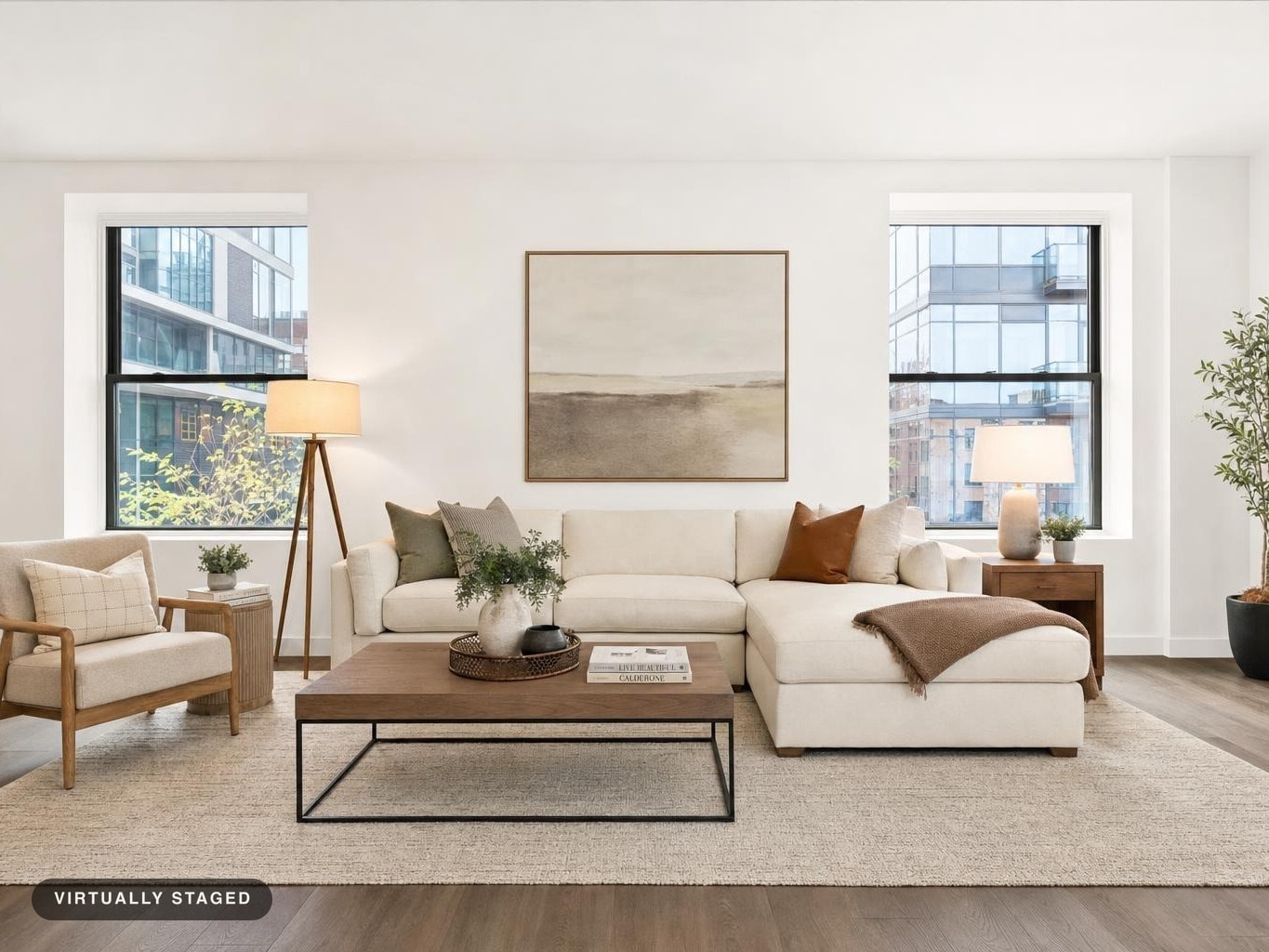 Modern living room with cream sectional sofa, wood armchair, rectangular wood coffee table, and abstract wall art between two windows.