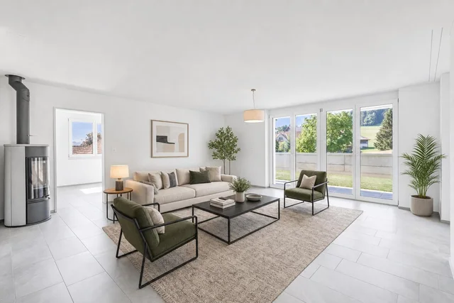 Bright modern living room with beige sofa, two olive green armchairs, black metal coffee table, large windows, and potted plants.