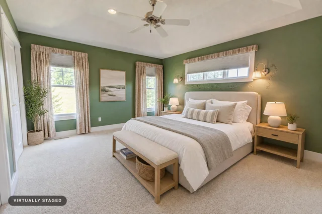 Bedroom with sage green walls, wooden bed and nightstands, beige carpet, and matching curtains.