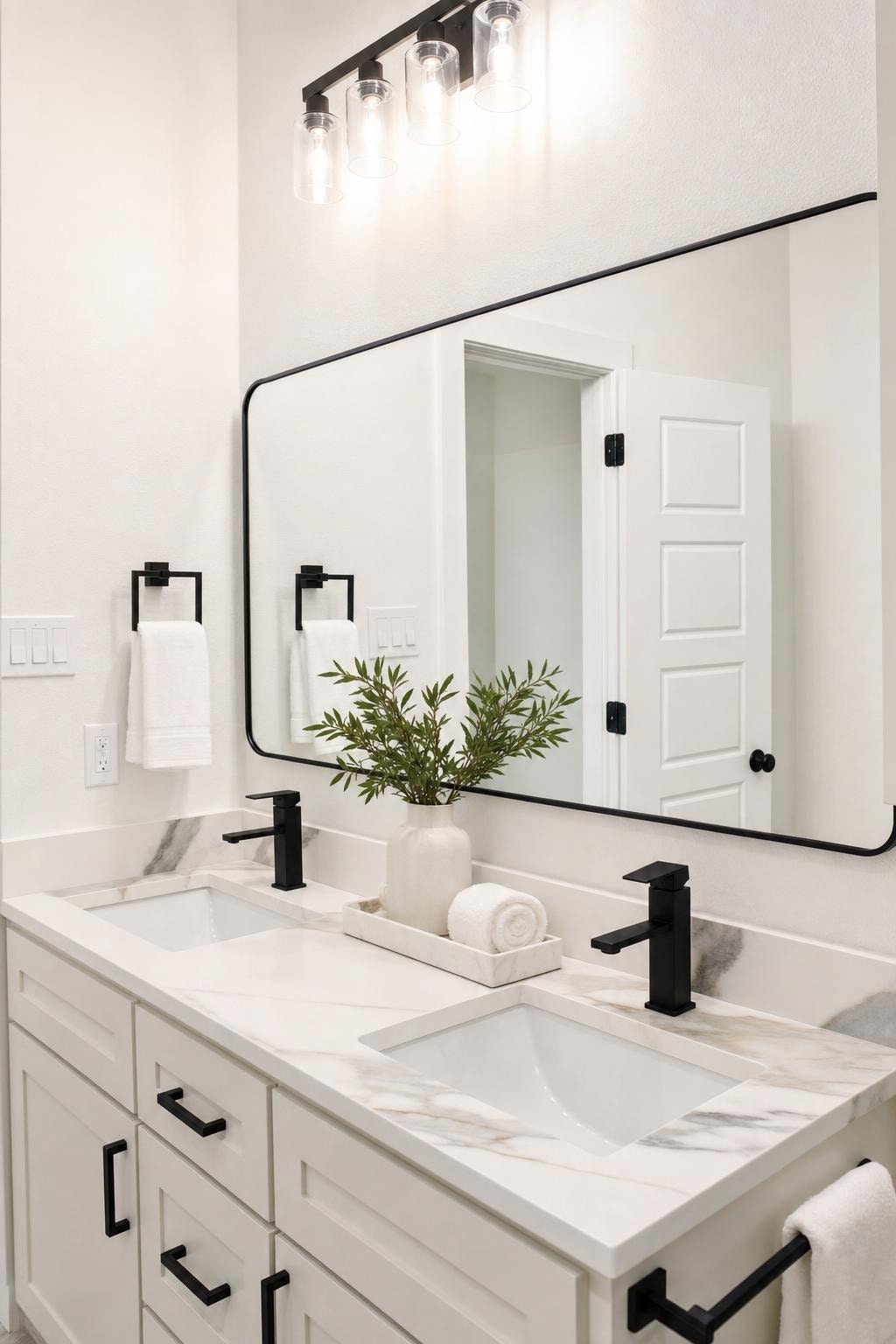 A modern double-sink bathroom vanity with white and gray marble countertop, black faucets, and a large rectangular mirror.