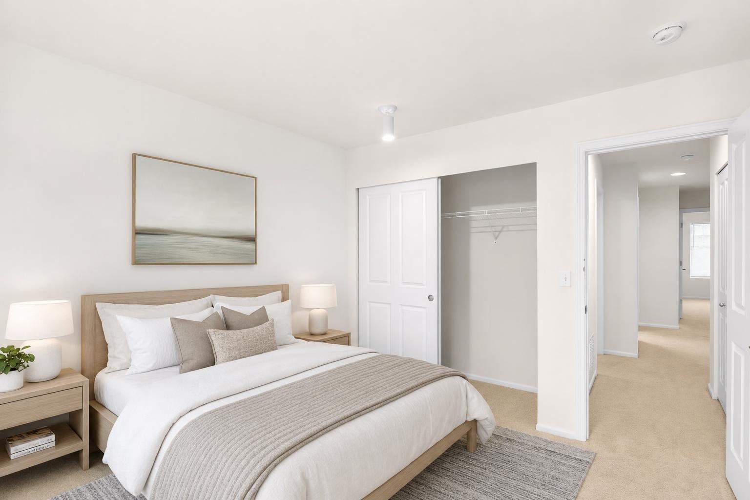 Scandinavian bedroom with a wooden bed, bedside tables, neutral bedding, and minimalist wall art.