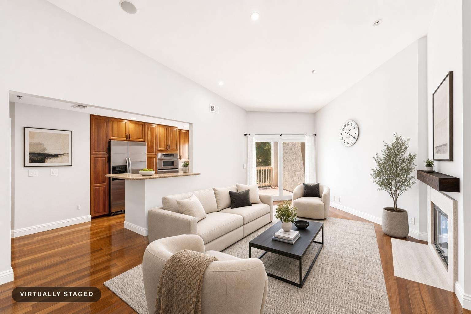 Bright modern living room with beige sofas, black coffee table on beige rug, wooden floor, and large window with curtains.