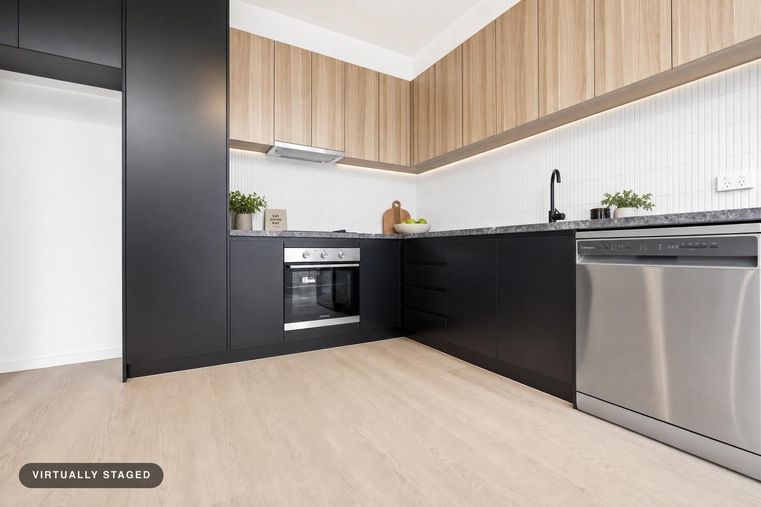 Modern kitchen with black lower cabinets, wood upper cabinets, stainless steel oven and dishwasher.
