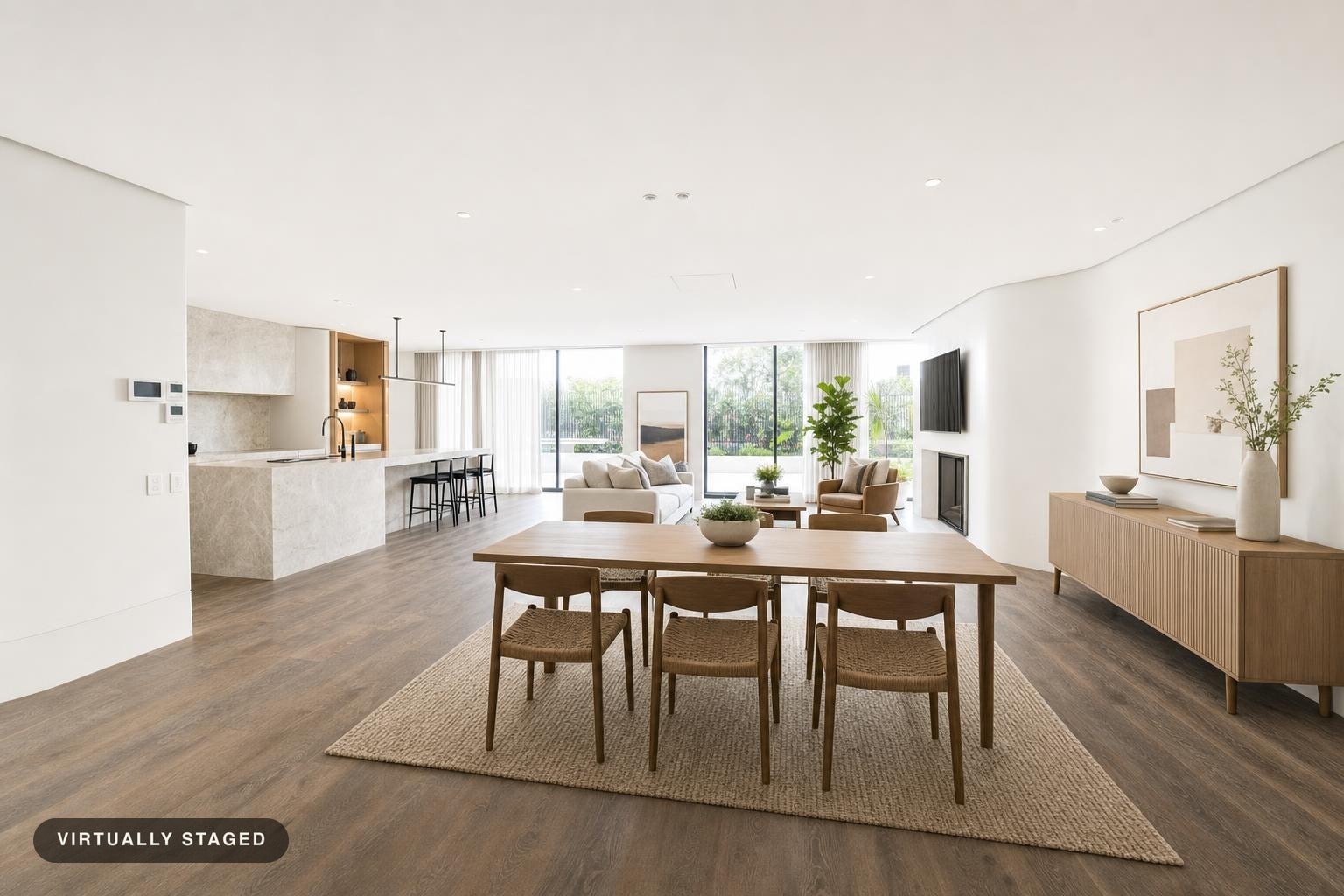 Open living and dining area with light wood furniture, large windows, and neutral decor in Scandinavian style.