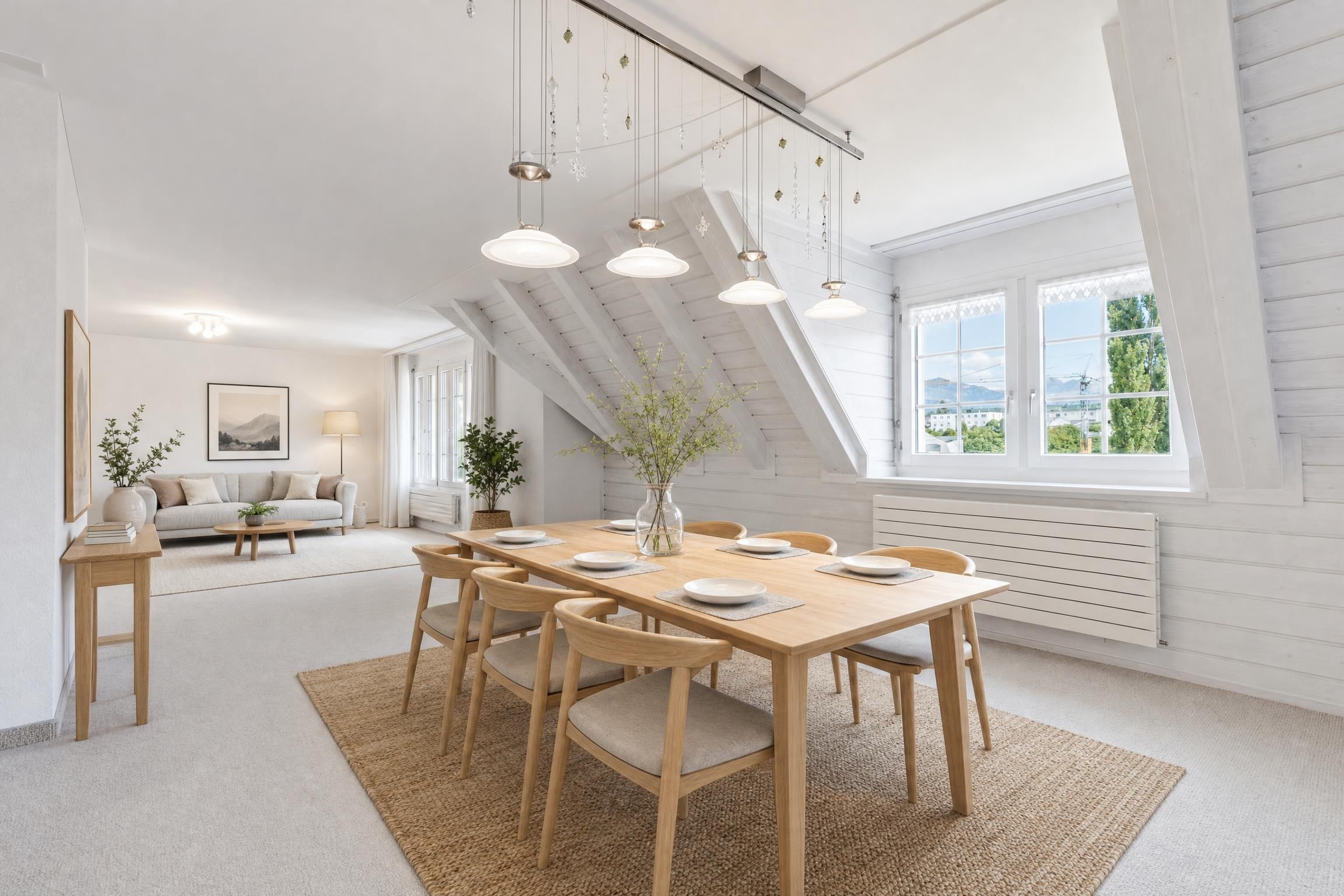 Light-filled Scandinavian dining room with wooden table, six chairs, jute rug, and a bright living area beyond.