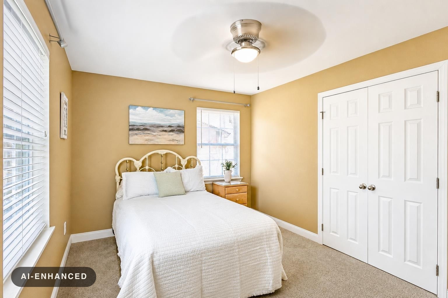 Bedroom with beige walls, white bedspread, decorative metal headboard, wooden nightstand with plant, white double closet doors.