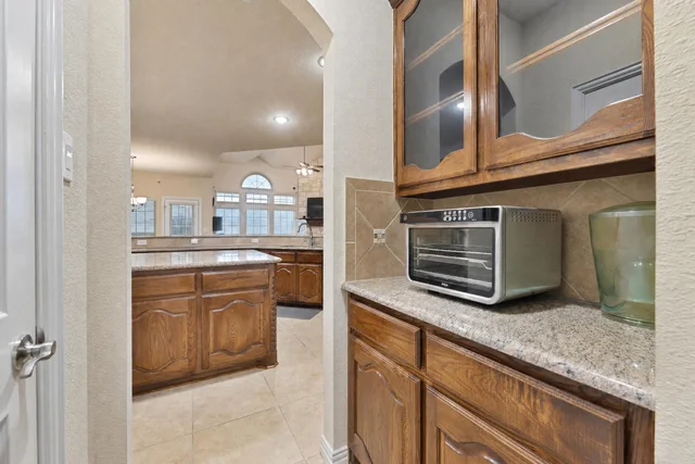 View of a traditional kitchen with wooden cabinets, granite-look countertops, and a small stainless steel toaster oven.