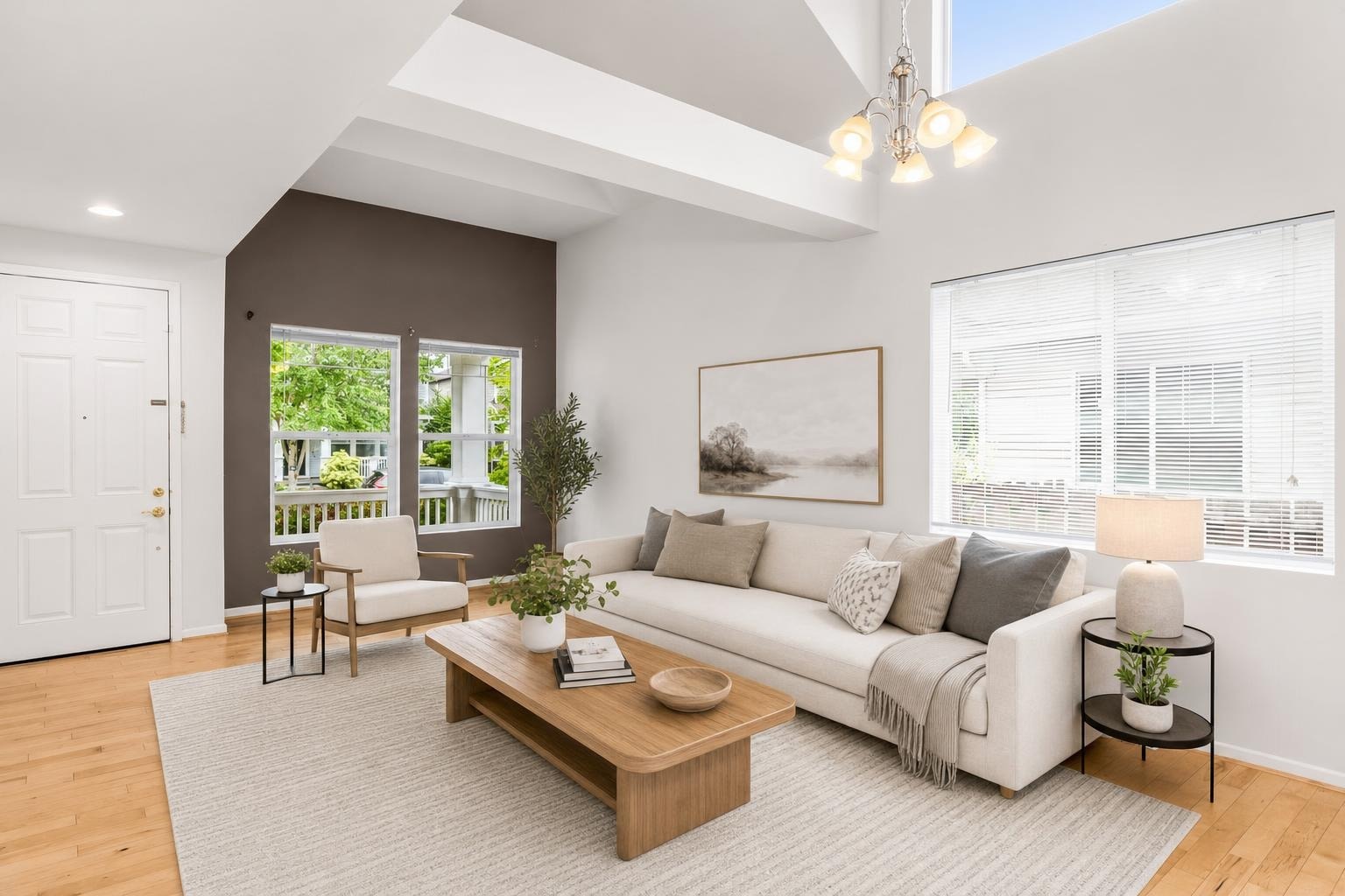 Scandinavian living room with cream sofa, wooden coffee table, armchair, side tables, and neutral decor under ceiling lights.