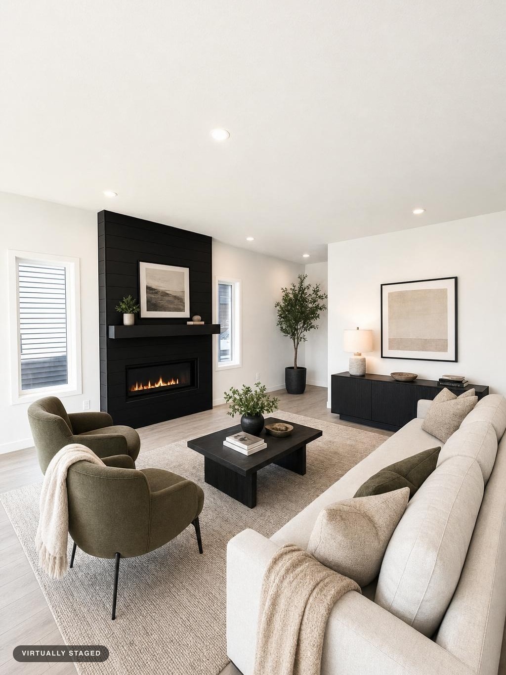 Modern living room with beige sofa, green armchairs, black fireplace, black coffee table, and sideboard under the window.