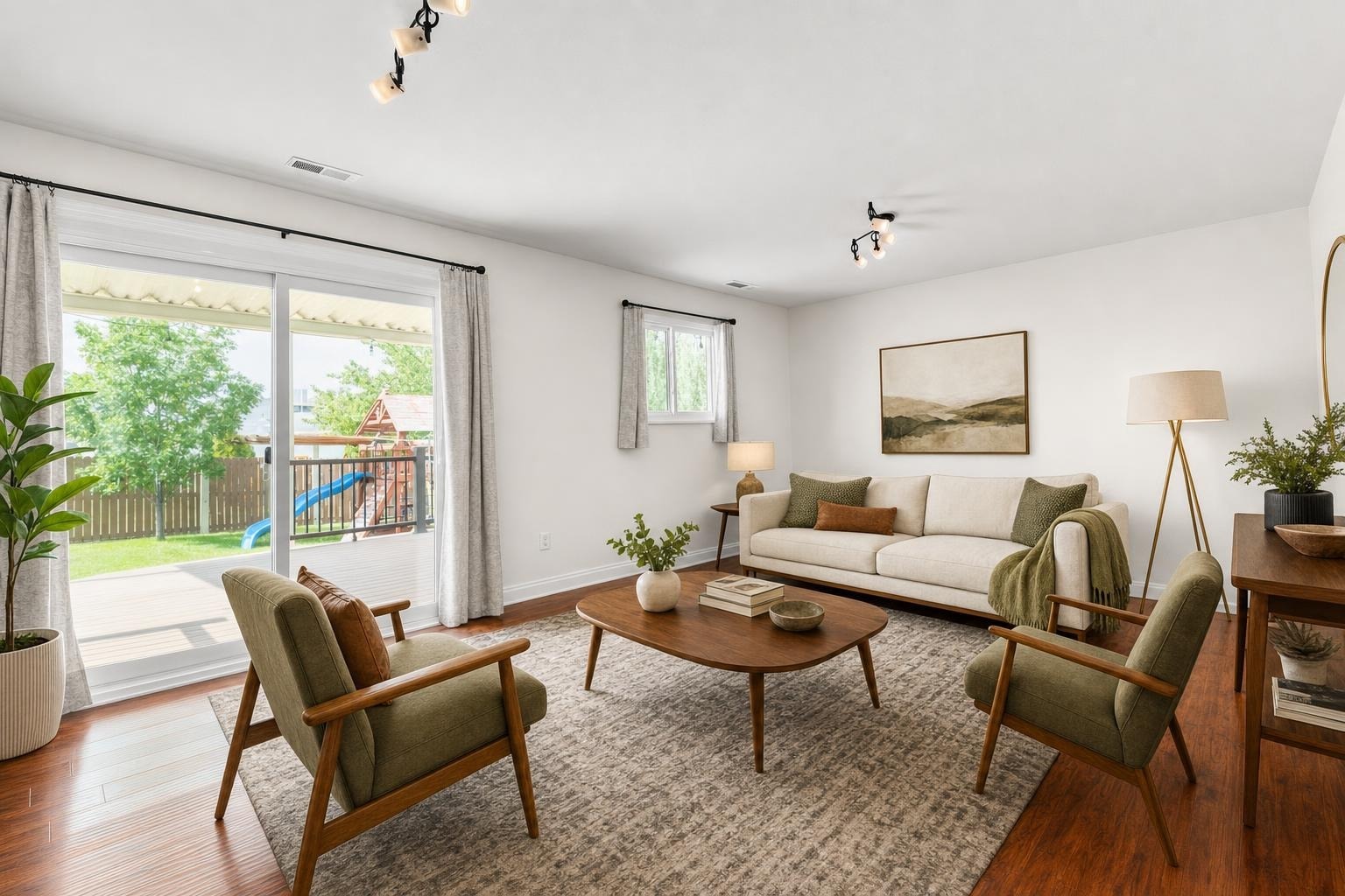 Living room with beige sofa, two olive green armchairs, wooden coffee table, and large sliding glass doors.