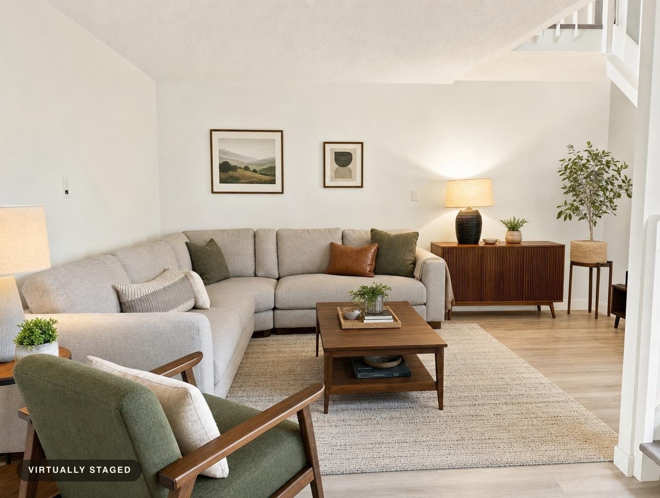 Modern living room with beige sectional sofa, green armchair, wood coffee table, wood cabinet, and light neutral decor.