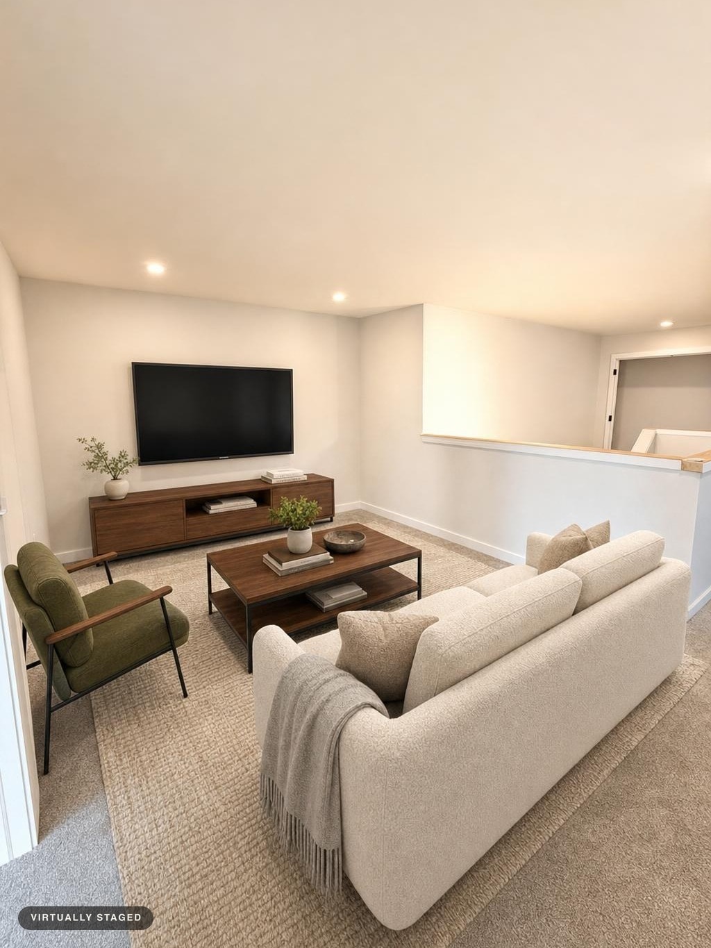 Modern living room with beige sofa, olive armchair, walnut TV stand and coffee table, neutral carpet, and light walls.