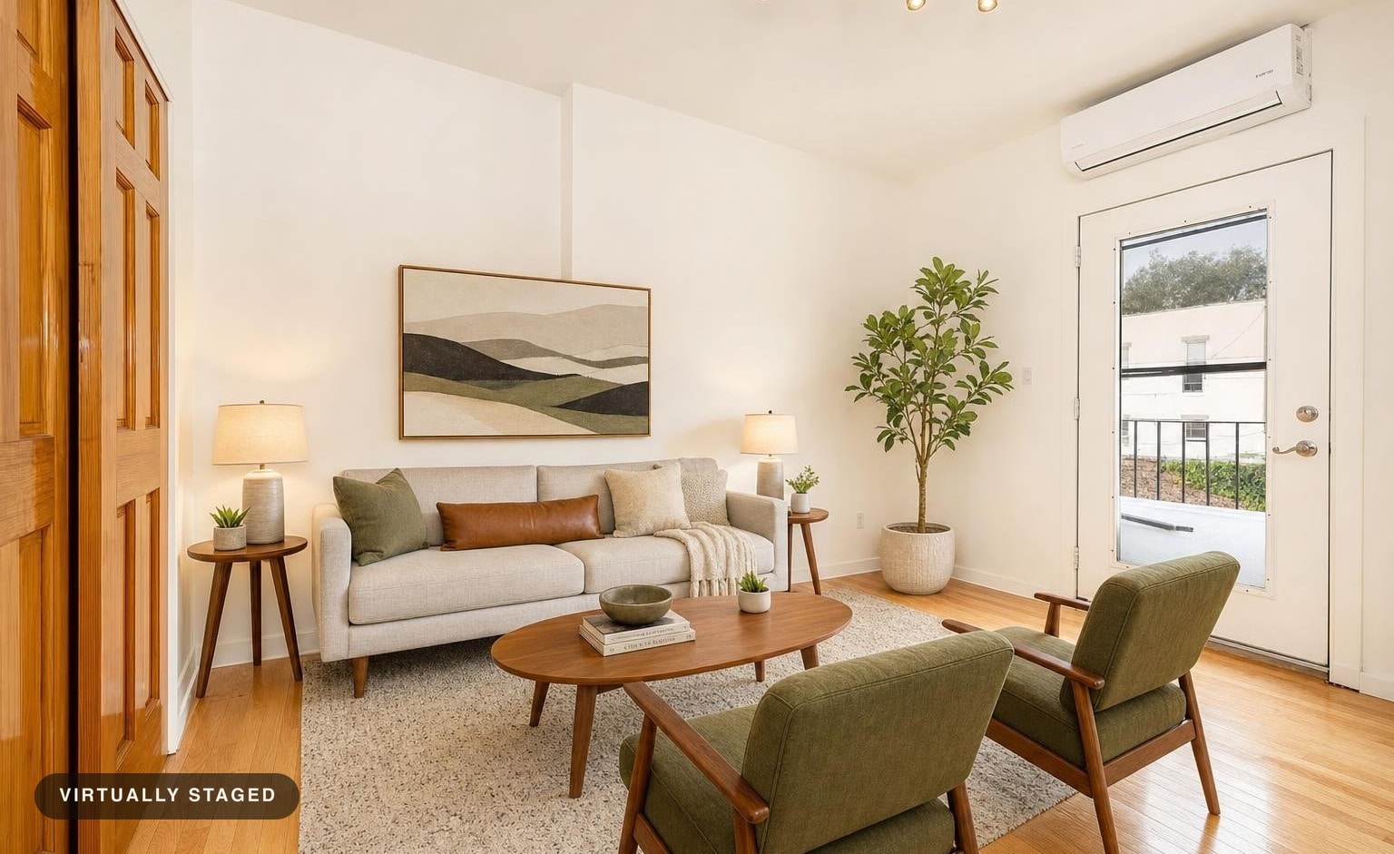 Living room with gray mid-century modern sofa, wooden coffee table, two green armchairs, side tables with lamps, plant, and abstract wall art.