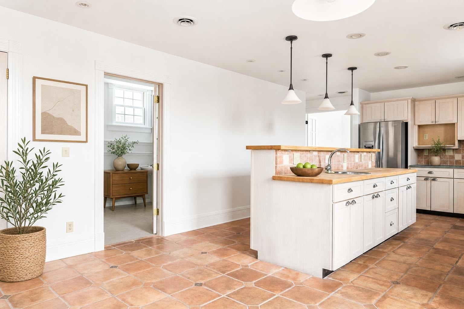 Modern kitchen with white cabinets, wood countertops, tiled floor, pendant lights, and a stainless steel refrigerator