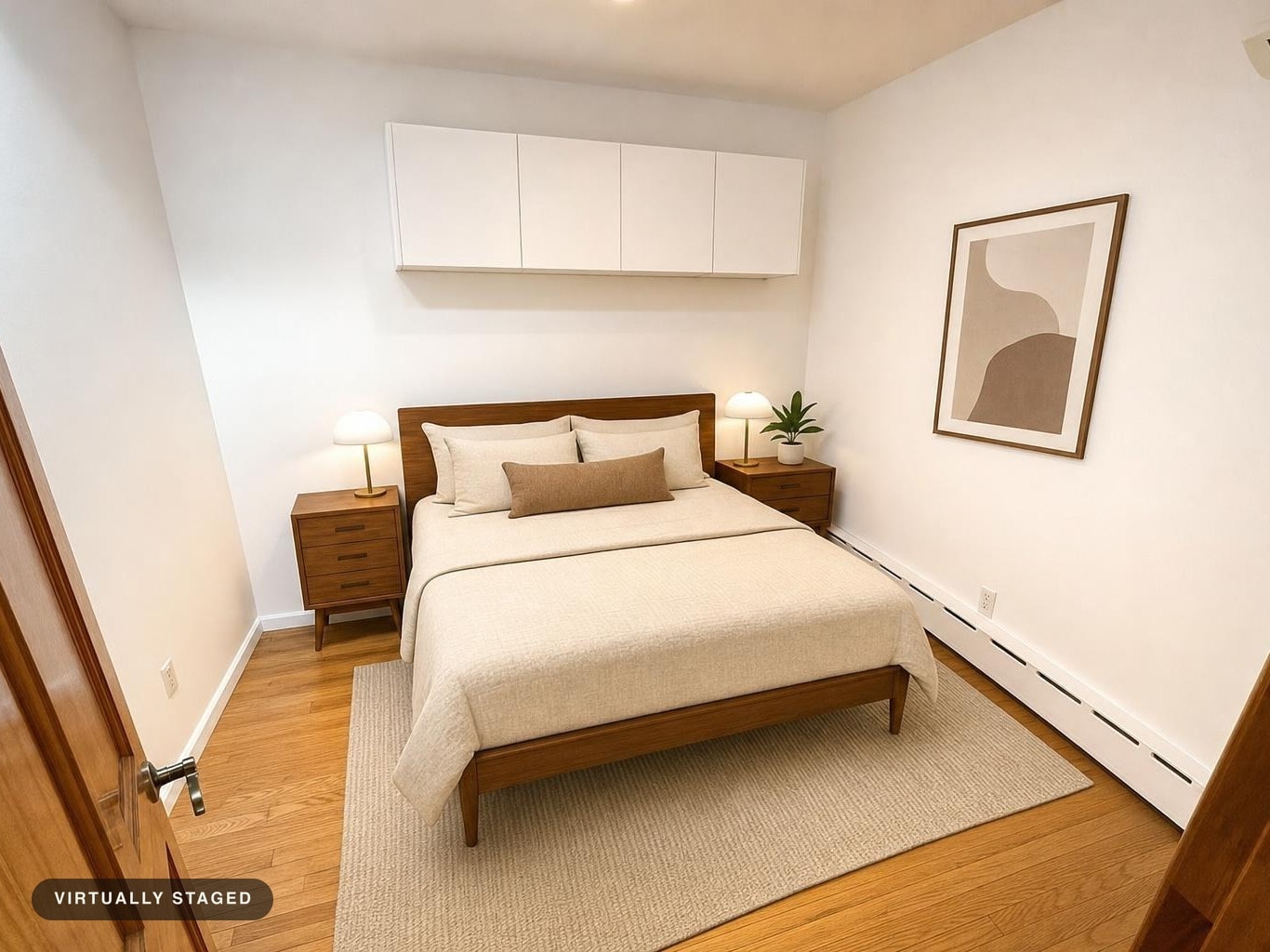 Neutral-toned bed with wood frame and matching nightstands, beige rug, modern lamps, and abstract wall art.