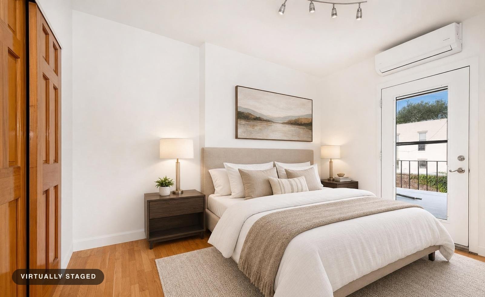 modern bedroom with beige upholstered bed, dark wood nightstands, table lamps, hardwood floor, and a landscape painting above the bed